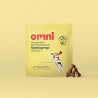Yellow package of 'omni' dog treats for growing puppies on a beige background