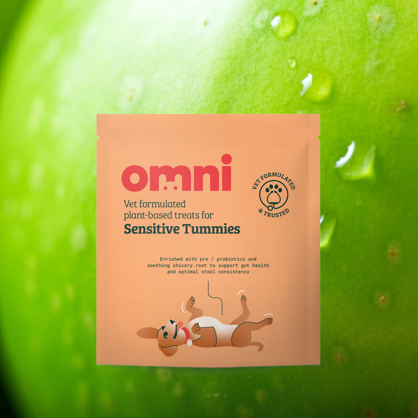 Package of 'omni' plant-based treats for sensitive tummies against a green apple background