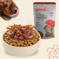 Dog eating from a bowl with Omni Toppers no-beef bites and dog food.
